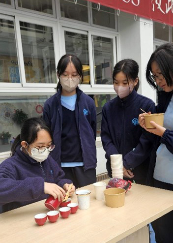 Shungtakians observing the process of a traditional Chinese tea ceremony
